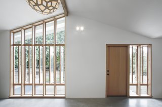"The bank of full-height windows brings in tons of southern light, but it also gives the stable a strong street presence, and it ties into the stick-built window pattern already established at the entry to the main house," Schaer says. The locally-sourced Douglas fir windows and doors were provided by Lindal Cedar Homes.
