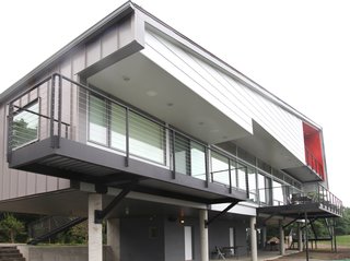 "A majority of the house is lifted on concrete columns to maximize the views and also provide a covered ground plane for protected parking and outdoor living," Mulvena says. "Future additions to the house can be built on this ground level within the existing structure."