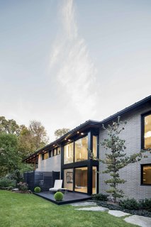 How to Refresh a Midcentury Gem in Quebec? Winter-White Everything - Photo 6 of 12 - The addition of a glass wall in the center of the property further opens the interior space to the outside and allows for an additional source of natural light.