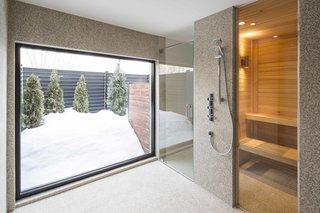 How to Refresh a Midcentury Gem in Quebec? Winter-White Everything - Photo 12 of 12 - The lower floor houses a spa, gym, and office. A built-in bathroom by Espace Cuisine includes a sauna.