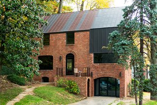 In Arlington, Virginia, a drafty house was made more than twice as efficient with the addition of metal both inside and out. Roof panels topping the brick envelope echo its original geometry. 