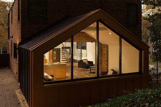 Like the exterior, the open-plan living area combines reclaimed materials, including the pre-existing black walnut floors.