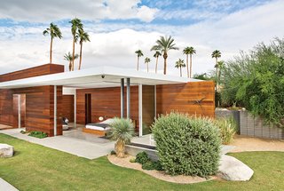 The master bedroom opens on two sides to the outdoors, where Lockyer placed a custom black-chrome wall clock.