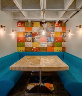 The studio created a breakfast nook with a colorful mural in the heart of the home. The metal sconces are custom. 