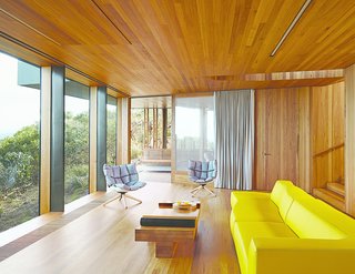Refusing to fixate on the seascape at the expense of other views, Wardle oriented the living room to a lush grove of trees. A yellow Bend sofa and two Husk chairs, both by Patricia Urquiola for B&B Italia, add splashes of color.
