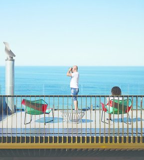 The rooftop terrace is furnished with a Tropicalia chair and chaise longue, designed by Urquiola for Moroso, and a Jil table by Justin Hutchinson for Tait Outdoor.