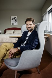 Jaime Hayon is Given the Keys to an Iconic Copenhagen Hotel - Photo 2 of 9 - Hayon sits in the Ro armchair he designed for Fritz Hansen, one of the items he placed in the room. "As an artist and a furniture designer, I focus on the small elements rather than the big space," he says. "If you're comfortable on your chair, and it feels good, that's a really good starting point to have a successful space. Then I focus on the rest of the room in terms of color, ambiance, and lighting." 