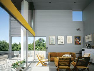 The Iconic Home That Still Looks as Good as New - Photo 2 of 6 - Inside, the slim cedar boards wrap the walls horizontally, a visual trick that seemingly expands the home's petite footprint.