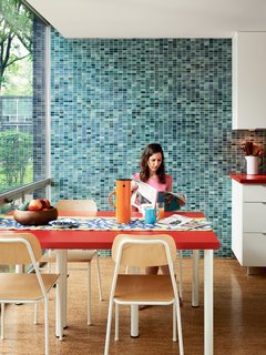 Because the original kitchen had been removed, Alexandra made the decision to widen the gallery-style room by ten inches. Floor-to-ceiling glass makes for ample natural light in the eating area, while the Vitra wall tiles provide a contemporary touch.