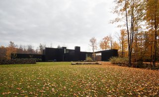 This Family Never Has to Fight About Where Their Next Trip Will Be - Photo 1 of 4 - The black-lacquered aluminum panels and double-height volumes of this home in southern Quebec, designed by Les Architectes FABG, abstract its scale from the outside.
