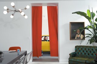 This is How You Combine Modern Architecture, Flea Market Finds, and Art All Together - Photo 2 of 8 - "Inherently, the house feels like a gallery." Surratt says, referring to their wide range of furniture and objects. "I love to juxtapose all of it together. It does all hang well together because of the space Studio Gang designed." Where the dining room and garage connect is just one example of the modern structure supporting the whimsical collection owned by the couple. 