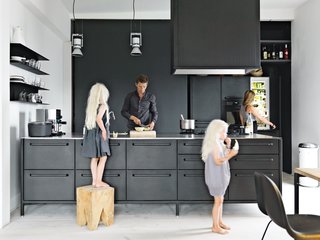 Twin daughters Merle and Anine join their parents in the family's kitchen, designed by Jensen for Vipp. He explains that his role of chief designer at Vipp is to "work with their DNA" by refining the company's trademark materials: stainless steel, painted, metal, and rubber. For the utilitarian kitchen, "we wanted to get the feeling of a tool" he says. "It's nice to have a space where you can actually work." The gas stovetop is by ABK and the refrigerator is by Smeg; Le Perroquet spotlights are from iGuzzini. 