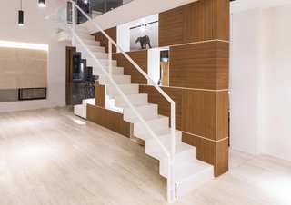 A thin floating staircase rises to the second floor almost weightlessly. 