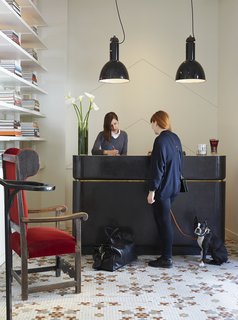 In the lobby, guests are greeted at a reception desk fabricated by NYC company FERRER and illuminated by vintage pendants sourced from Belgium. The ornate tile on the floor is original—a nod to the building's past.