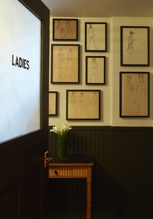 Illustrations discovered at Paris's Les Puces flea market adorn a bathroom wall. 