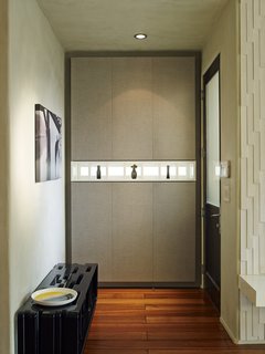Just inside the front door, another piece of custom casework is made from the Corsican Weave laminate from California Closets.