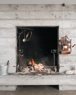 In the living room fireplace, a bird turns on the antique French spit. 