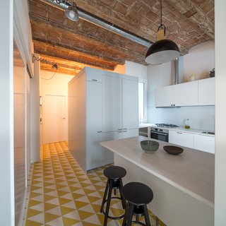 The most striking feature of the original apartment was the vaulted ceilings with wood beams, which were kept intact. A geomteric hydraulic mosaic flooring covers the kitchen. 