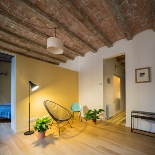 The partition separating the bedroom from the living room appears to be a partial wall—but in reality, a mirror extends from the top of the wall to the ceiling. 