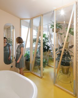 Making use of the benefits of moisture for plants, this small greenhouse has been created between a humid bathroom and a small private shower area of an apartment. 