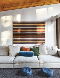 The Ski Retreat for All Seasons - Photo 1 of 10 - In the living room, an 18th century jajim, purchased in Istanbul, hangs behind a Molteni & C sofa covered in woven linen with mohair pillows. The wool rug is from California Carpets. 