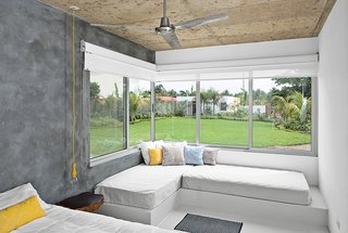 Bursts of Yellow and Indoor Gardens Are Just Two Reasons to Love This Home - Photo 5 of 5 - In the main bedroom, the beds are built in, the walls are concrete, the ceiling fan is by Westinghouse, and the pendant light was fashioned from an extension cord.