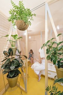 A canary yellow–floored bathroom with corrugated plastic walls is the centerpiece of the renovation. 