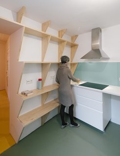 At just under 1,400 square feet, the three-bedroom apartment benefits from built-in space savers including sawtooth shelving and even a fold-out bench.
