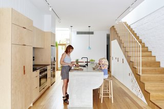 It Looks Like a Playland but This Home Works Hard - Photo 3 of 10 - The narrow kitchen is brightened by a soft material palette. A burnished concrete countertop flows like a waterfall into the Blackbutt timber flooring. The translucent blue Poly Pop pendant is by Tokenlights. 