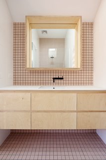 It Looks Like a Playland but This Home Works Hard - Photo 8 of 10 - A second bathroom is clad in soft pink tile. All the matte-black fittings in the bathrooms and kitchen belong to the Yokato collection by Brodware. 