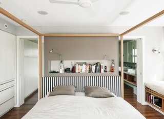 An Alcova bed from B&B Italia dominates the master bedroom. A niche behind the bed holds Berenice wall lamps by Luceplan, and the walls are painted in Cornforth White and Charleston Gray from Farrow & Ball. 