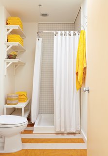 How a Smart Interior Design Saved This House - Photo 8 of 9 - In the guest bathroom, a set of Senegalese nesting baskets mirrors the yellow-and-white pattern on the linoleum floor.
