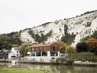 Sandy Rendel Architects replaced an old workshop with a striking new home in Lewes, East Sussex, England. The structure is located right at the edge of the town, in a spot that formerly functioned as a wharf to an adjacent quarry. Due to its prominent siting, the planning authority wanted to see a bold design that would signal the town's entrance. The building shell, made of SIPS, was prefabricated offsite, allowing for significant time savings in construction.