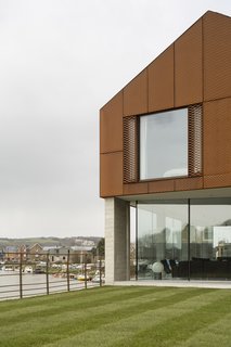 The upper story is clad in a decorative rainscreen of Cor-Ten steel mesh, chosen in part for its tone, which complements the red clay brick used locally. "The external materials were all selected to be robust and self-finished," says Rendel. "They will weather naturally, develop character and patina, and require very little maintenance." 