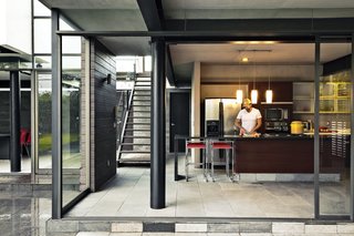 Two Brothers Bring Their Families Together to Share a Scenic Getaway - Photo 4 of 6 - Alfredo chops away in the kitchen, which features floor-to-ceiling sliding glass walls. 