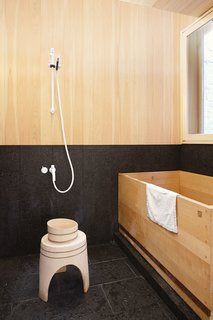 In a home in Toronto designed by Studio Junction, several Japanese pieces in the bathroom, including a bowl, stool, and custom bathtub, are crafted from hinoki, a bacteria-resistant Japanese cedar that prevents mildew and withstands humidity. 
