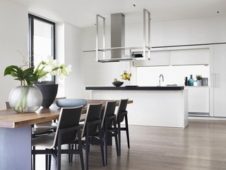 Soothing hues ranging from white to gray pair with warm woods throughout the residence. The dining area feature Who chairs by Rodolfo Dordoni for Molteni&C. 
