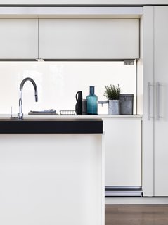 The kitchen—a customized version of the Dada Tivalì system, designed by Dante Bonuccelli, with a Hi-Line6 hood and island—was imaged as a white monolith that can be hidden behind doors tucked within the framework. 