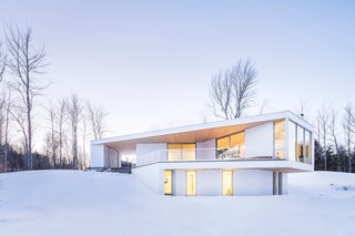 This Snowbound Pad Will Actually Make You Miss Winter - Photo 2 of 3 - An interior balcony on the 3,000-square-foot home's lake-facing side provides a place for outdoor relaxtion in warmer months. 