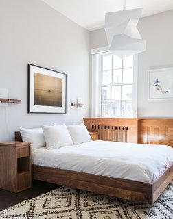 The Simple Hi bed by Formstelle defines the bedroom, which also features a custom nightstand by Reddymade Design, Levo sconces by Cerno, a vintage Moroccan rug, and an Isamu Noguchi pendant.