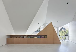 The storage unit is built with a vertical grain oak. Modal Design worked with cabinet makers Scanlon Construction to follow the specific roof angles. 