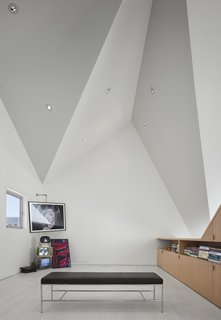 The ceiling features pin lights that effortlessly blend within the folded surfaces to make the studio feel as spacious as possible. 