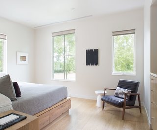 The house is well-equipped for guests, with multiple sleeping areas. The main guest room features a custom reclaimed oak bed by BenchCraft and a Callan chair from Room & Board. 