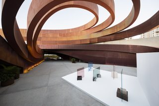 The courtyard contains a site-specific installation called "In the Shade" that features sheets of colored glass by Glas Italia anchored by Caesarstone pedestals.