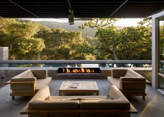 Concealed speakers from James Loudspeaker, scattered throughout the indoor and outdoor rooms, let the residents stream music from their phones. A trio of love seats and a coffee table from Henry Hall’s Tru/Pure collection form another outdoor room. 