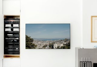 From the gray leather Roche Bobois sofa, one can take in a view of the surrounding city via a television wired to a rooftop camera. The control center for the home’s automation systems is concealed inside a nearby cabinet.