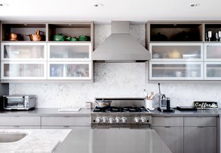 The search for a 13-foot-long island to fit their kitchen led them to marry Calacatta Miele and stainless steel to make one giant counter. Marble, they discovered, was available only in 10-foot slabs, due to the dimensions of shipping containers.
