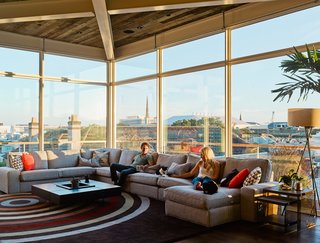 Rich and his girlfriend Arielle sit on an IKEA sofa; the windows are from Charleston Glass. 