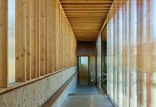 Simple passageways with polycarbonate glazing, wood framing, and polished concrete floors connect the structures. 