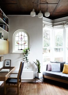 The original coffered wood ceiling of Kate Tucker and Tom Crago’s home in Melbourne, Australia, provides a dramatic backdrop for a vintage pendant from Angelucci 20th Century. "The bay windows and high ceilings were so lovely, we really wanted to do as little as possible up front," Kate says of the plan for the house. 